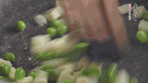 鍋中油7成熱時(shí)，入青豆、筍丁翻炒，然后加糯米飯加鹽均勻翻炒。