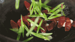 先后下香腸片、四季豆絲均勻翻炒，加適量清水燜煮一下。