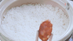 煮開后轉(zhuǎn)小火，當(dāng)米飯出現(xiàn)小孔時(shí)，鋪上金字麻辣香腸。