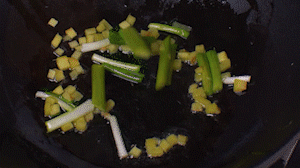 鍋中熱油，依次下姜粒、蔥段、蘆筍炒香。