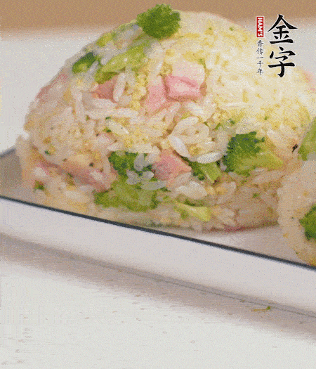 拌好的飯攥成飯團(tuán)。