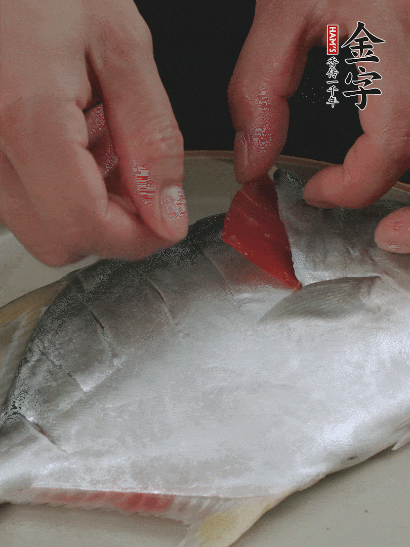 火腿片和姜片塞在刀口處，也塞一些入魚(yú)肚。