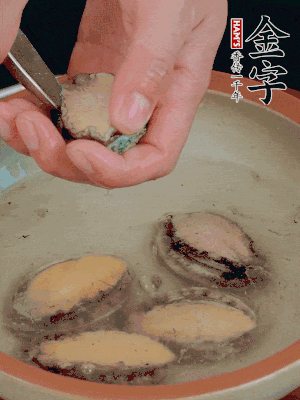 鮑魚加鹽、清水浸泡，用勺子挖出鮑魚肉。