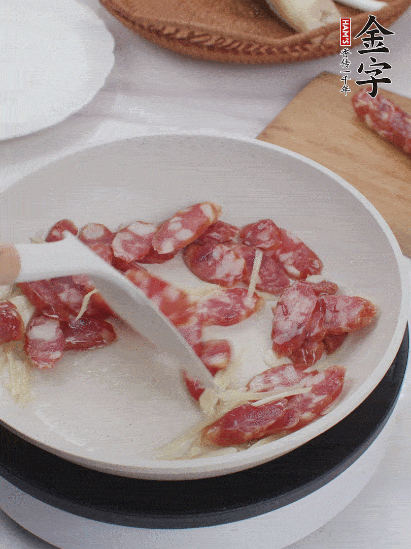 油溫3成熱時，下姜絲、蒜片、香腸炒出油脂。