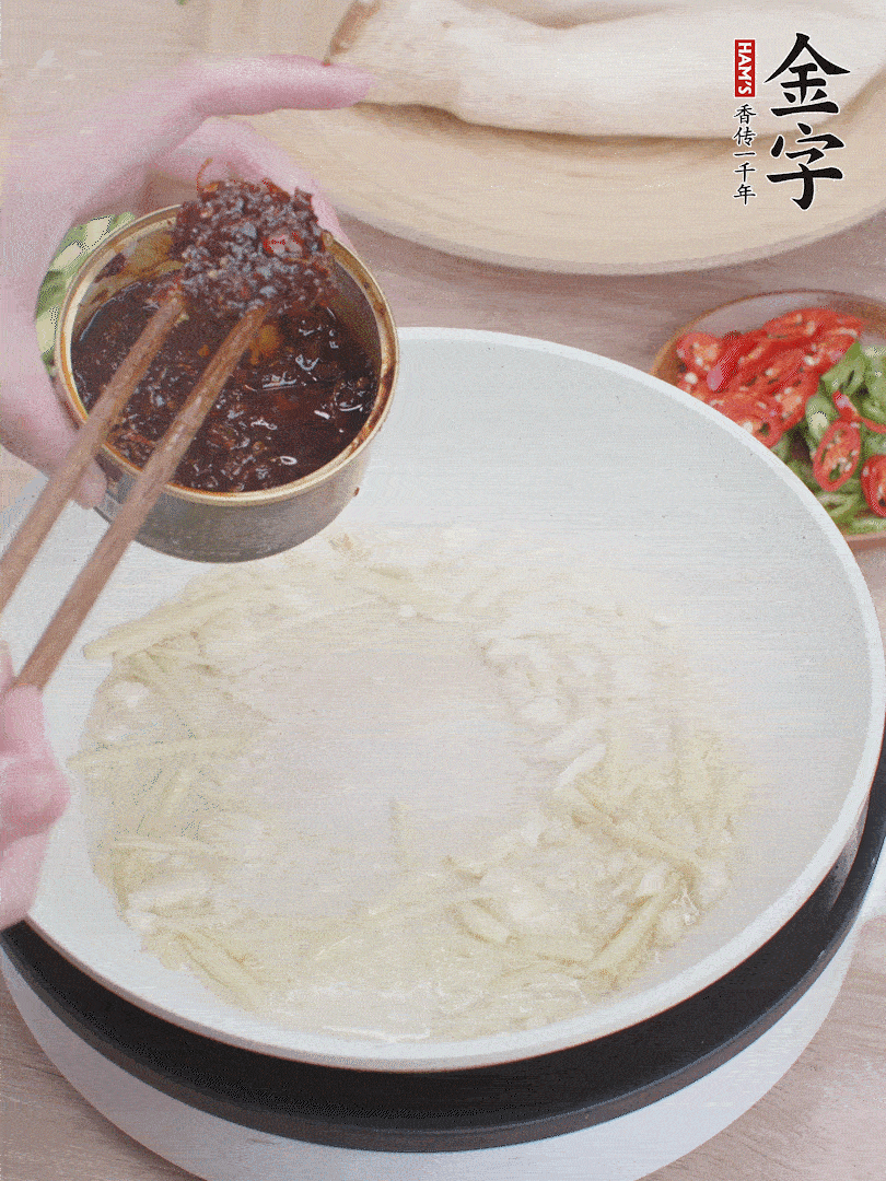 起鍋熱油，姜蒜、金字火腿干貝醬煸香。