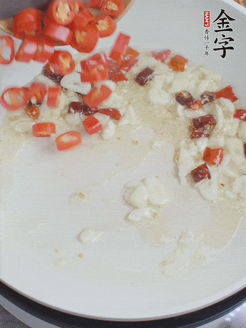 油6成熱，下蒜末、干紅辣椒煸炒，出香味后再放美人椒、香腸。