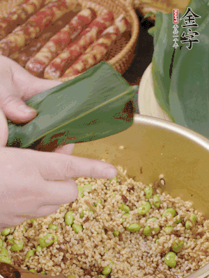 粽葉往下折，完全蓋住，兩側(cè)捏緊。