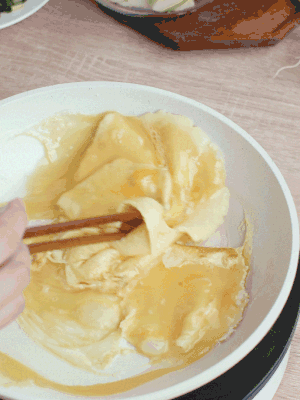 油6成熱時(shí)，下雞蛋液，邊緣凝固時(shí)翻拌成塊狀。