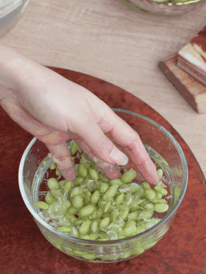 青豆剝殼，搓去外衣。