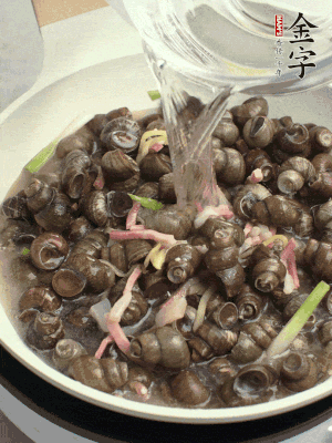 倒處理干凈的螺螄翻炒，加3勺料酒。加清水蓋過螺螄，中火蓋蓋煮5分鐘。
