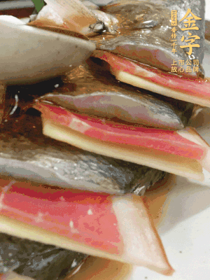 魚肚中塞蔥結(jié)、火腿片，魚身上碼放姜片、火腿片，倒入混合的料汁。