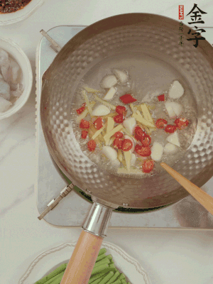 油7成熱時(shí)，下大蒜粒、姜絲、小米辣煸香。