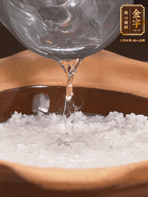 砂鍋底部刷一層油，加入大米和開水，水高1cm,大火燒開后轉(zhuǎn)中火煲5分鐘，到水微收干