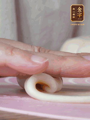 做面劑 油皮按扁，中間包入一個(gè)油酥，邊緣收緊捏死。包好的面劑按扁，用搟面杖搟壓成橢圓形。從底部向上卷成筒狀，用保鮮膜蓋好松弛15分鐘，再把筒狀縱向搟壓成長(zhǎng)條狀。再卷一次，松弛20分鐘