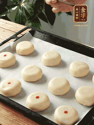 收口向下放在案板上，輕輕將月餅坯按扁，用筷子點(diǎn)紅點(diǎn)做裝飾