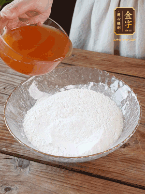 轉(zhuǎn)化糖漿、枧水、花生油攪拌均勻，加入面粉混合，醒發(fā)2小時。捏成23g一個的小球