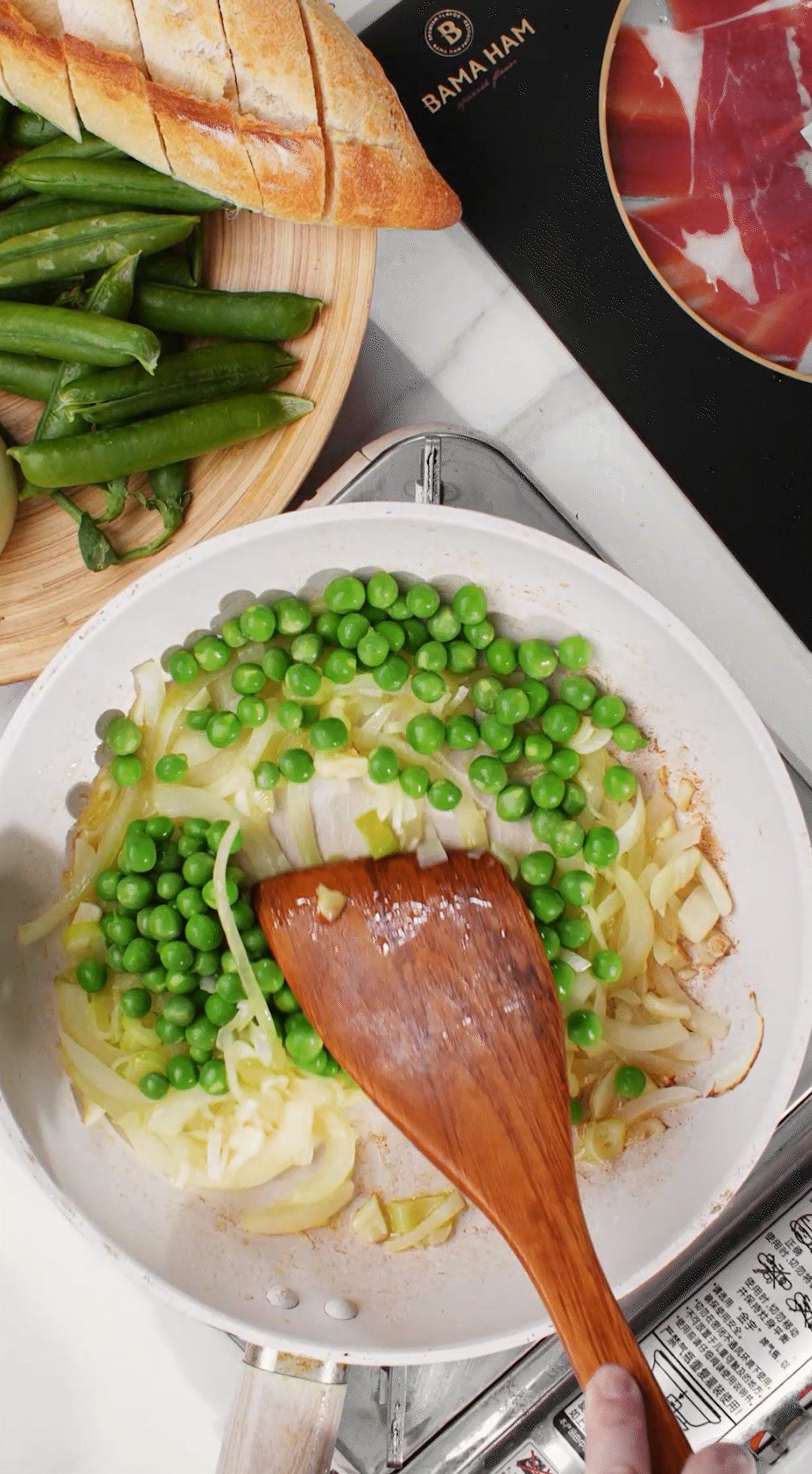 鍋中放入黃油融化，加入洋蔥絲、大蔥蔥白絲、蒜末翻炒變軟出香味。加入剛剛汆燙冰鎮(zhèn)后的豌豆，取出一點點待會擺盤裝飾用。加一點鹽 (和黑胡椒) 調(diào)味。