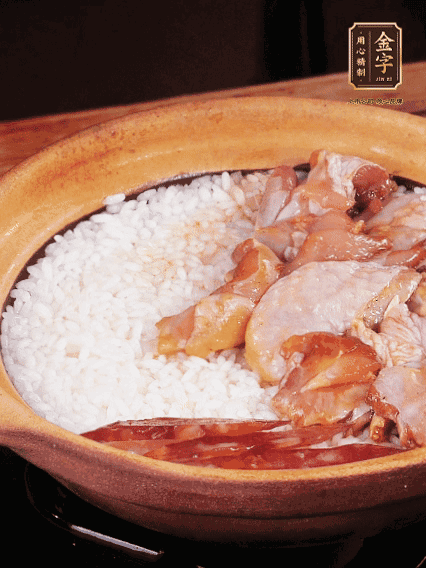 煮到椰子水微微收干轉(zhuǎn)小火，快速均勻鋪上雞肉、金字香腸