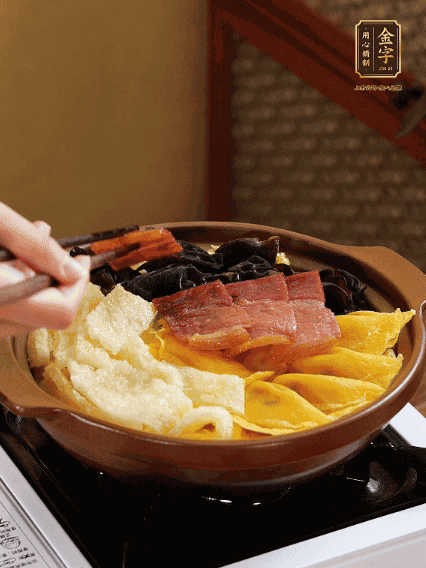 砂鍋底部鋪上娃娃菜，依次擺上肉皮、蛋餃、黑木耳、火腿