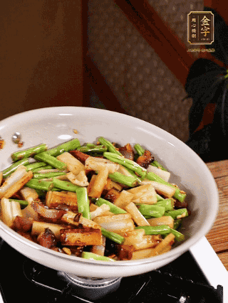油熱下蒜末、干辣椒、醬肉煸炒出香味，依次下藕條、豆角翻炒均勻